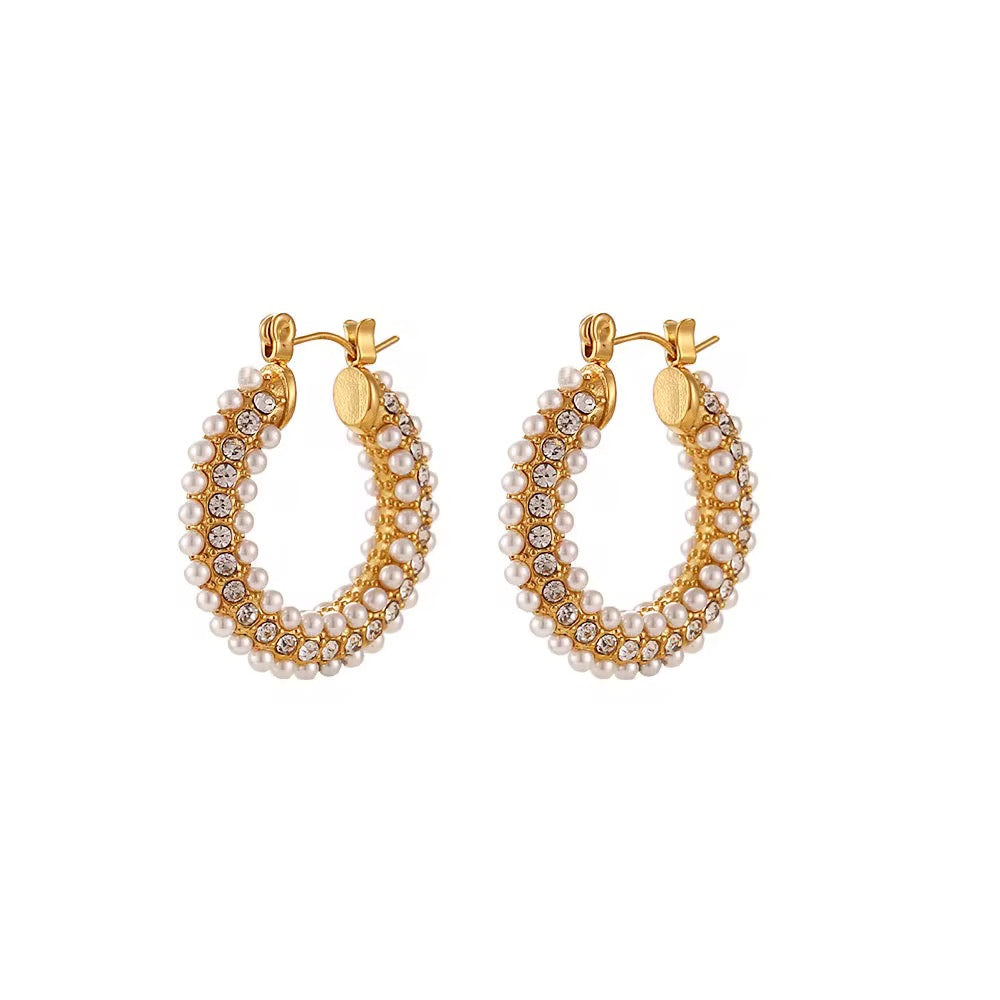 Gold hoop earrings with pearl and crystal detailing on a white background