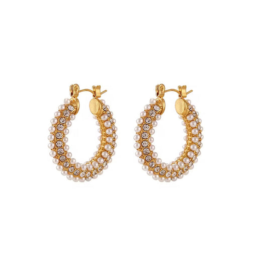 Gold hoop earrings with pearl and crystal detailing on a white background