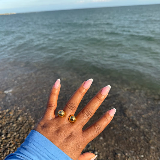 Hand with gold rings on a beach
