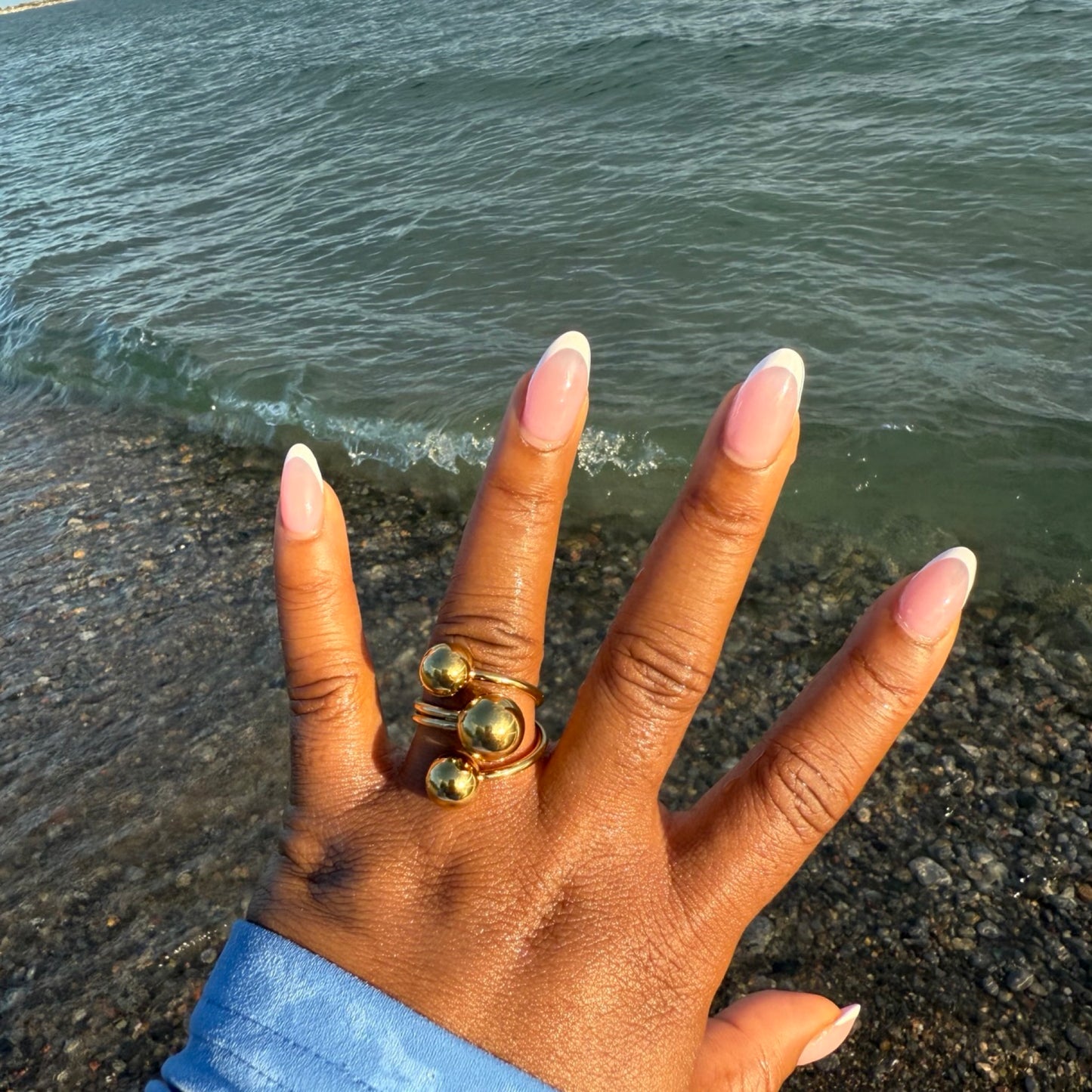 Hand with gold rings on a beach waterproof ring