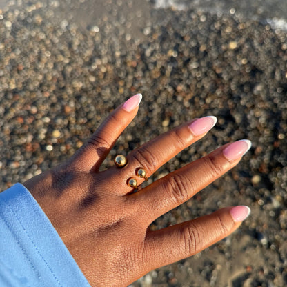 Hand with pink nail polish on a sandy background