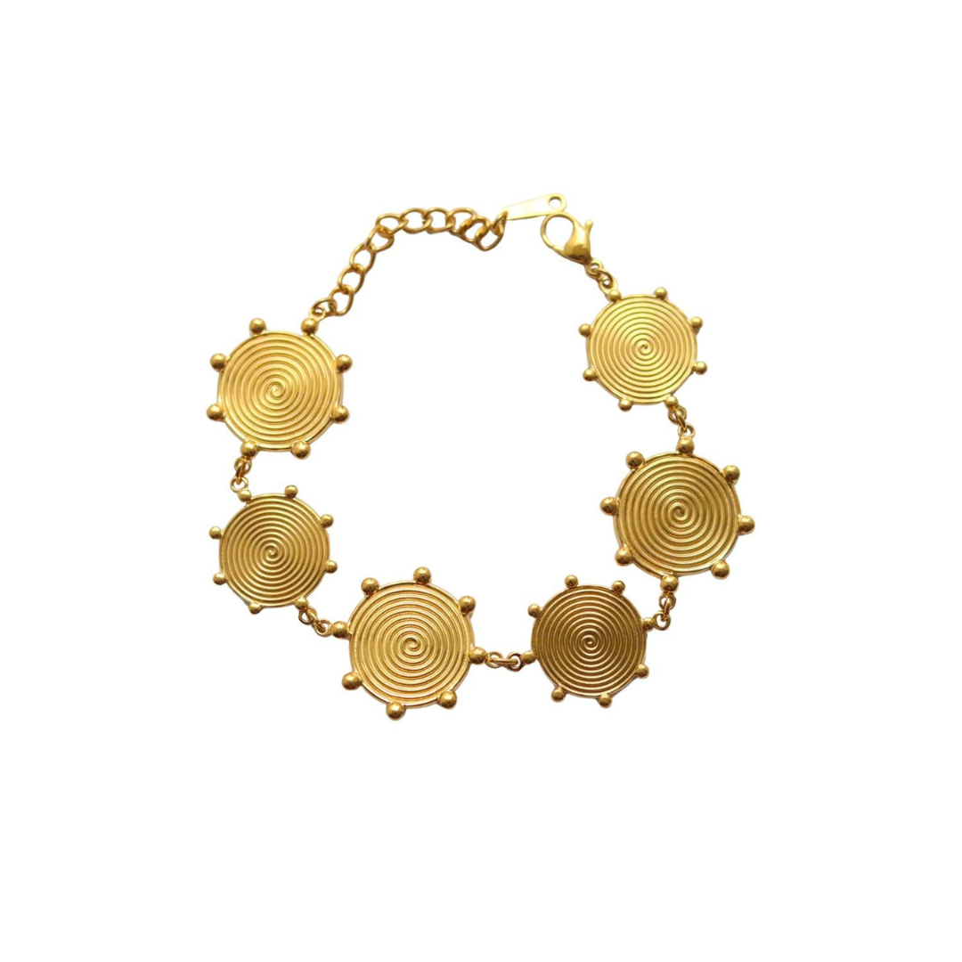 Gold bracelet with circular designs on a white background