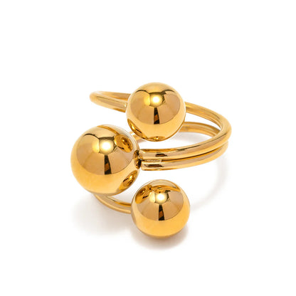 Gold ring with three spherical components on a white background
