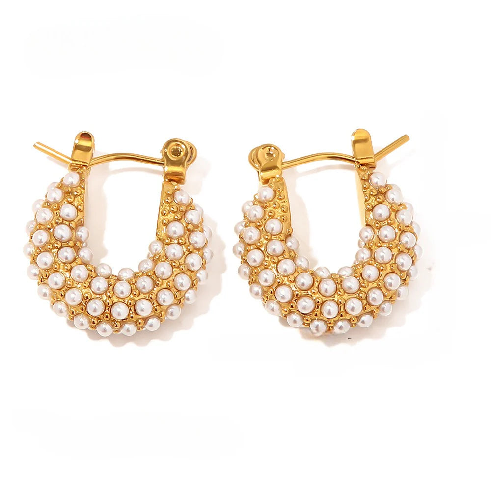Gold hoop earrings with pearl accents on a white background