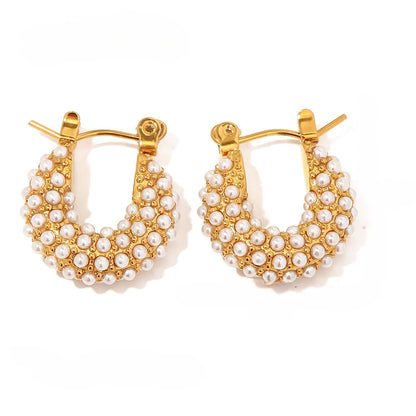 Gold hoop earrings with pearl accents on a white background