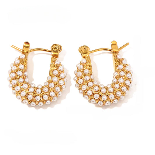 Gold hoop earrings with pearl accents on a white background