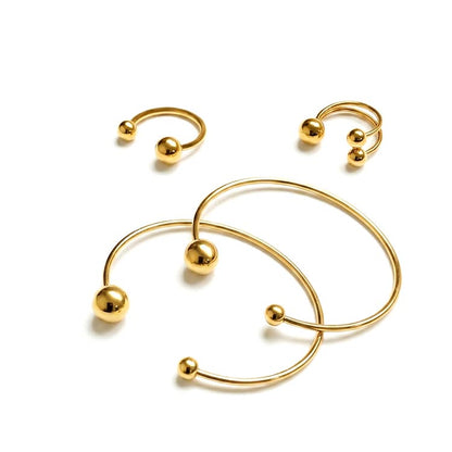 Set of gold hoop earrings with spherical accents on a white background